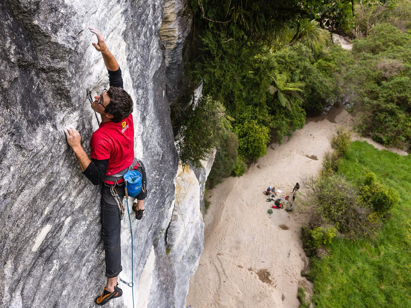 A climber leading an outdoor rock pitch